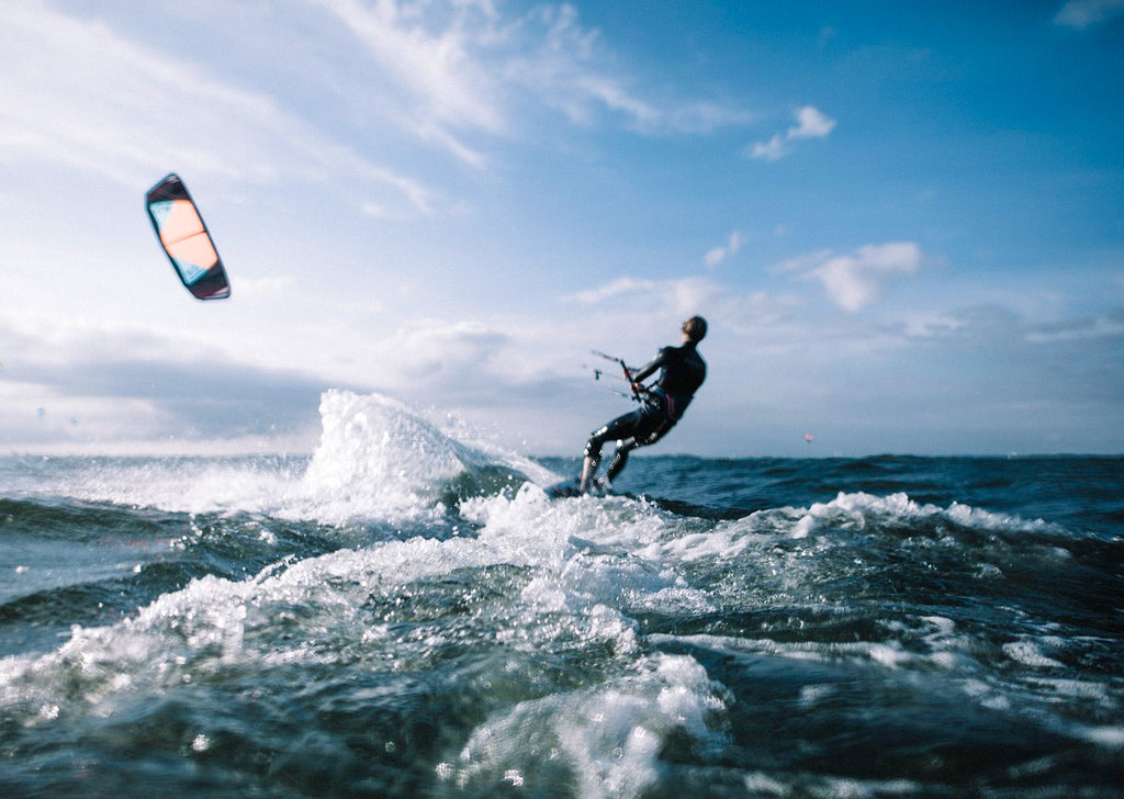 kitesurfing donna con muta che cavalca le onde