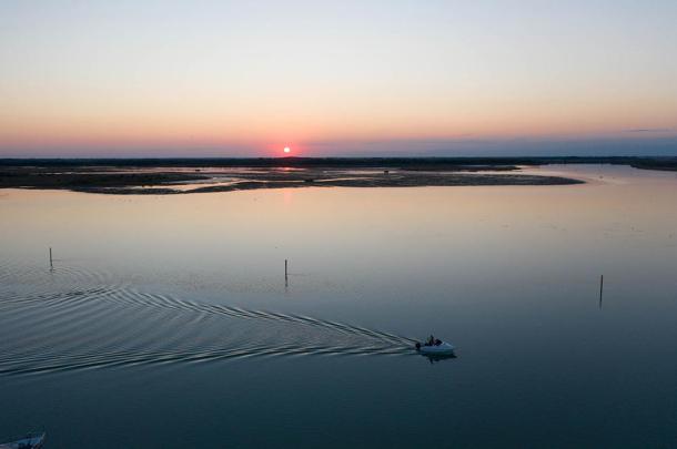 panoramica della laguna di Bibione col sole al tramonto e una moto d'acqua