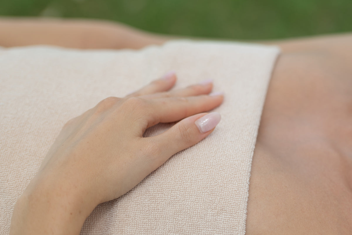 ragazza con mano su un panno sul petto. Trattamento spa