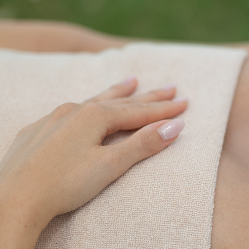ragazza con mano su un panno sul petto. Trattamento spa